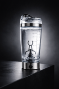 Clear shaker bottle with measurement markings on a dark background